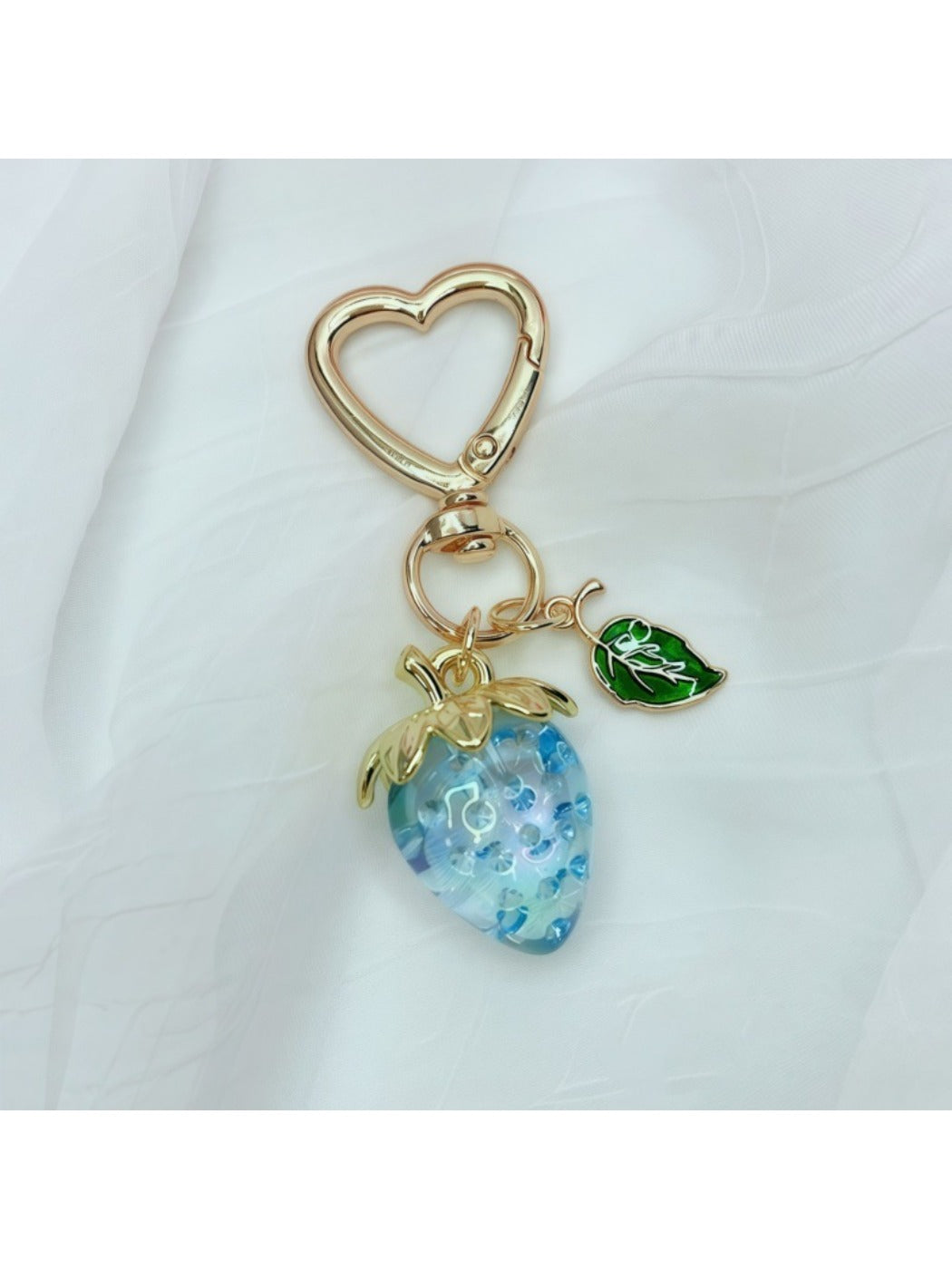 Keypus strawberry charm keychain attached to a backpack zipper pull