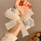 Soft lace bow hair tie wrapped around a ponytail on a model