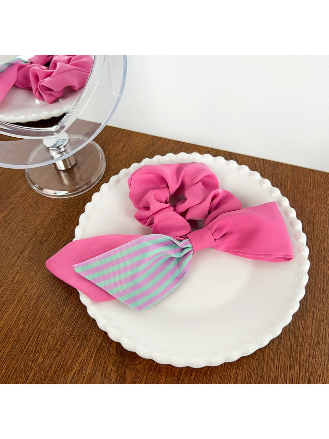Magenta striped scrunchie next to matching hair accessories