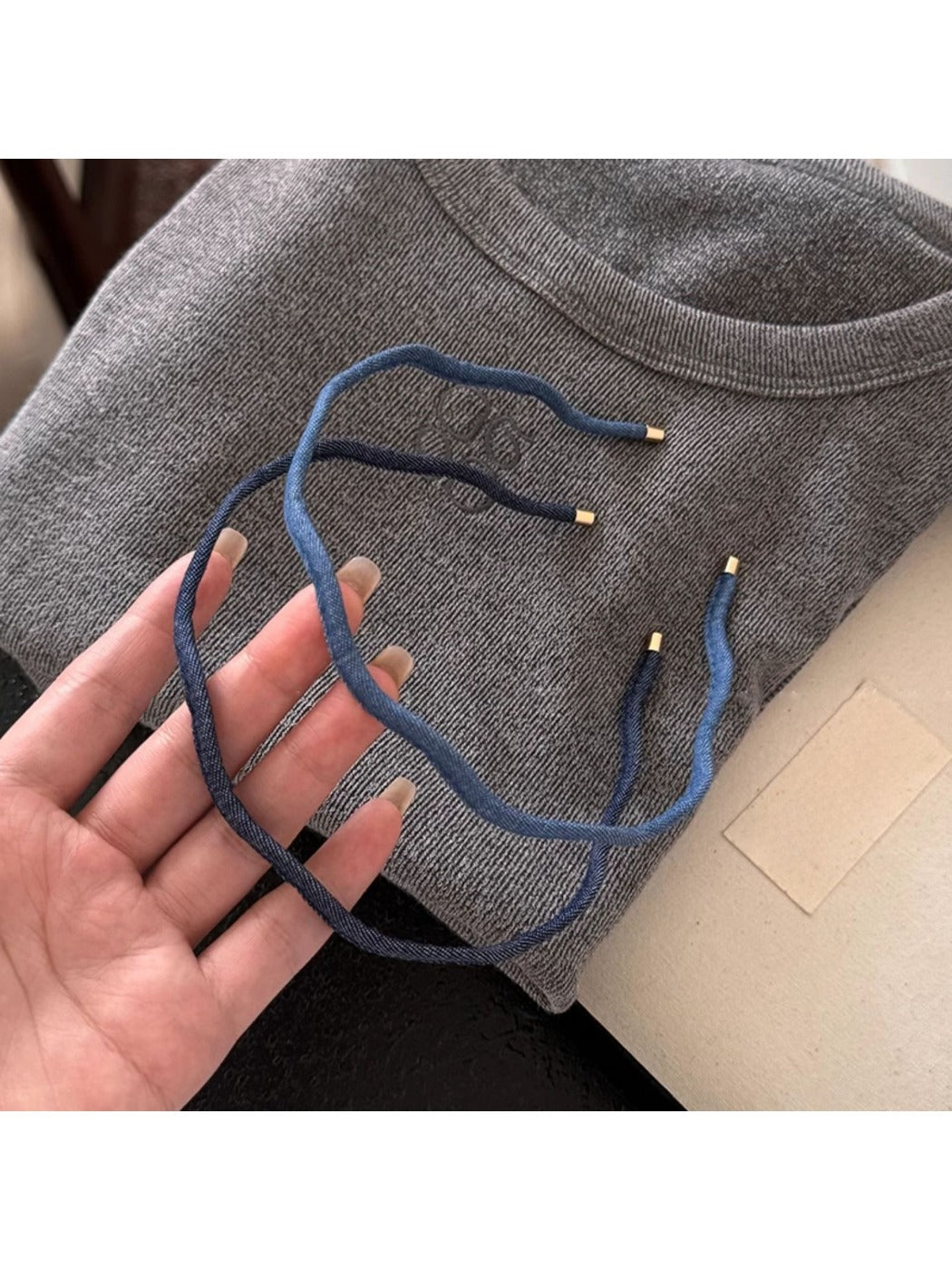 Side view of the denim wave headband showing its curved design