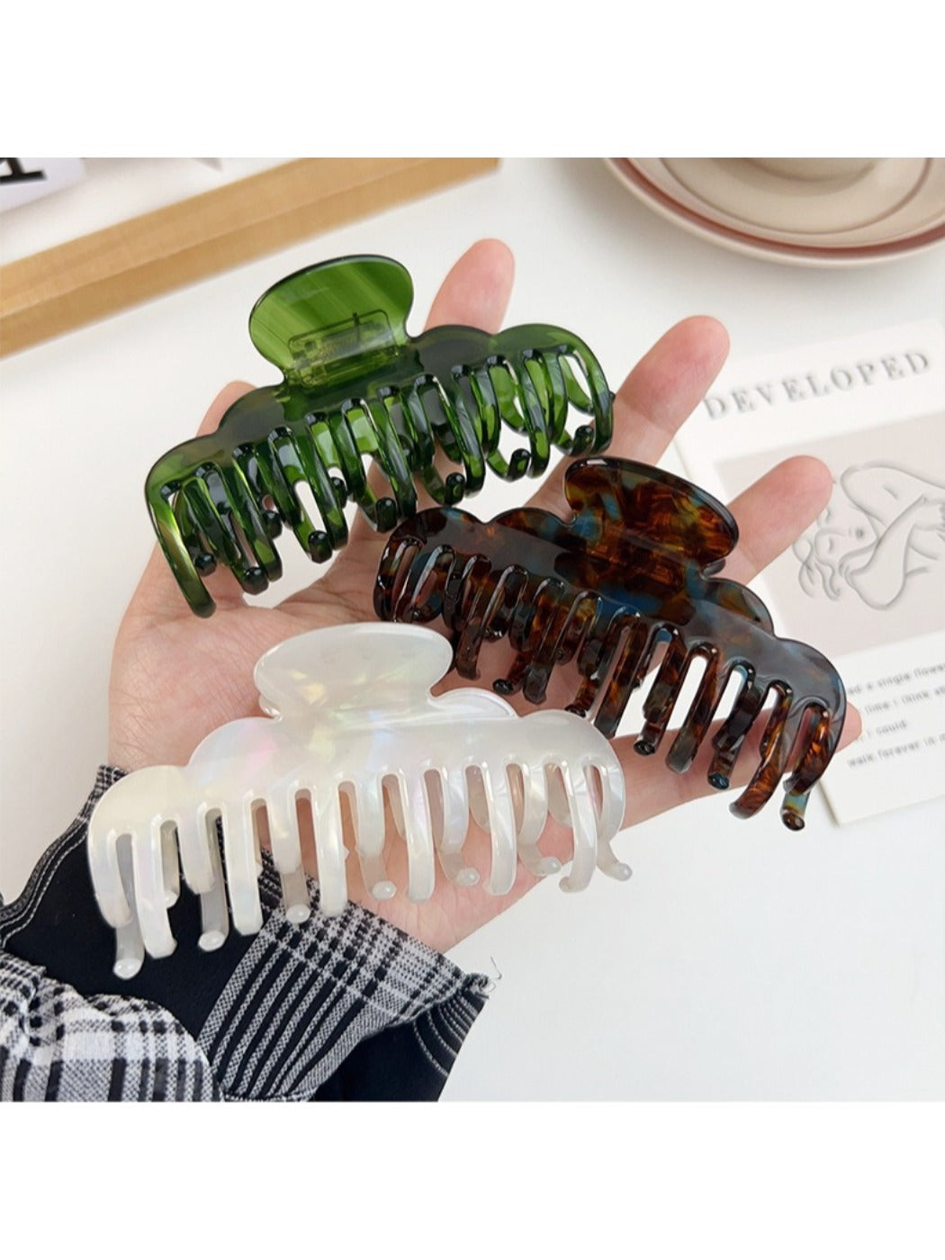 Beau claw clip open displaying spring mechanism and claw teeth