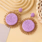Detailed shot of colorful raffia earrings showing natural fiber material