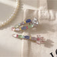 Beau hair clip worn in blonde hair, highlighting its vibrant pastel colors and floral design