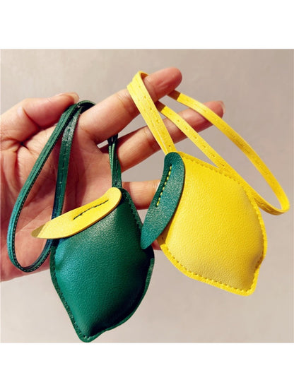 Lemon-shaped keychain hanging from a set of keys on a wooden surface