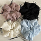 Close-up of a chic ribbon bow tulle scrunchie in soft pink on a white background
