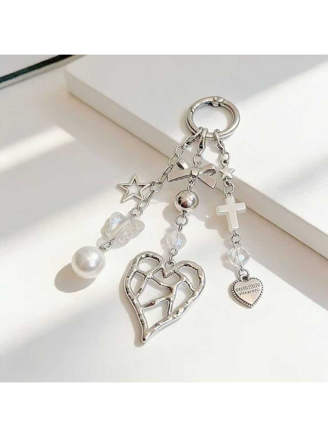 Heart shaped charm keychain displayed alongside keys on a wooden surface
