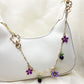 Side view of gold daisy pendant with white enamel petals and gold center