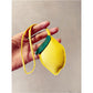 Lemon keychain attached to a backpack zipper outdoors