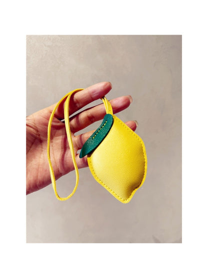 Lemon keychain attached to a backpack zipper outdoors