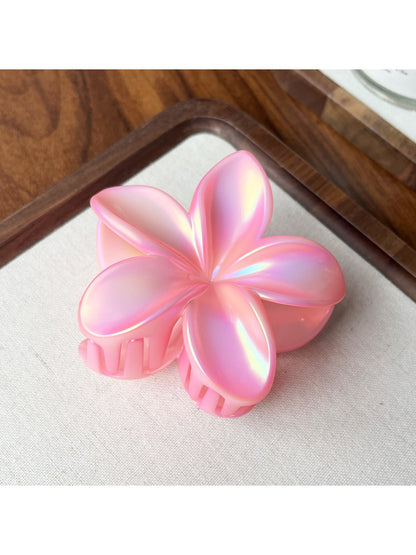 Beau flower shaped claw clip placed on a light neutral background