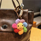 Keypus flower charm keychain hanging from a set of keys on a wooden surface