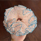 Gifty Hazy Elegant Mesh Scrunchie displayed on a wooden surface with natural lighting