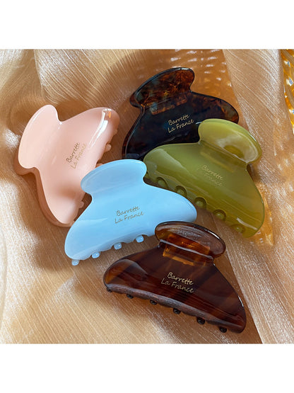 Beau Sweet Chic acetate claw clip holding a section of brown hair