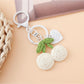 Side view of the Keypus cherry charm keychain highlighting the metal keyring