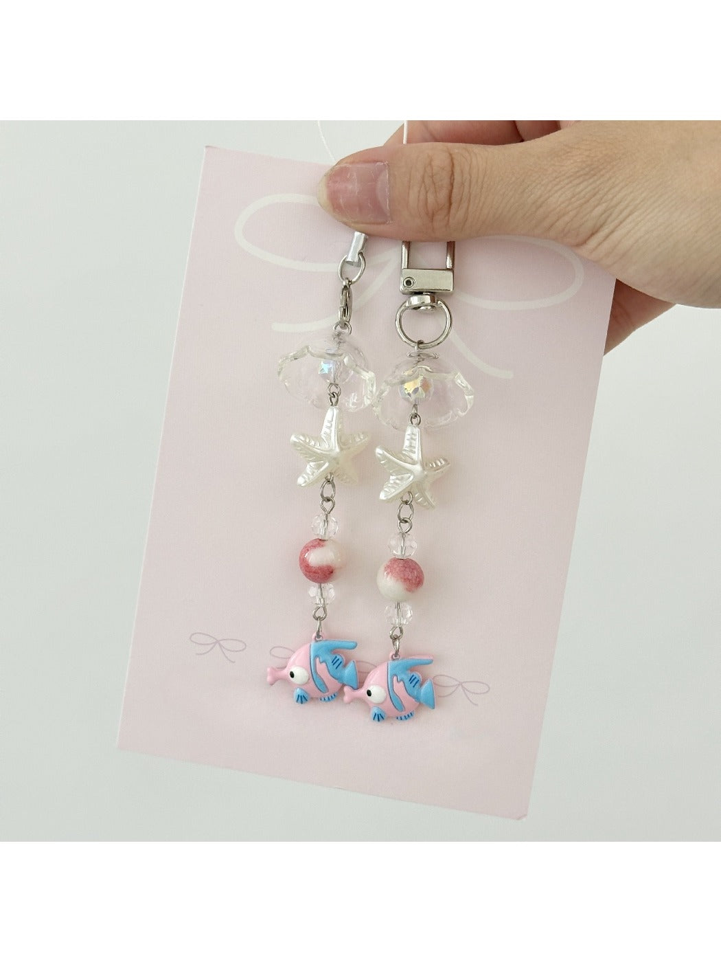 Pink fish keychain held in hand to show size and shape