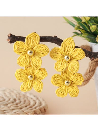 Close-up of gold hooks attached to raffia flower shaped earrings