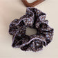 Gifty Retro Lace Floral Scrunchie paired with casual outfit on a wooden surface