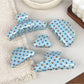 Side view of blue polka dot hair claw clip highlighting clasp mechanism