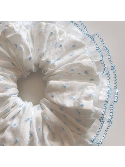 Close-up of Gifty polka dot scrunchie showing fabric texture and elastic band