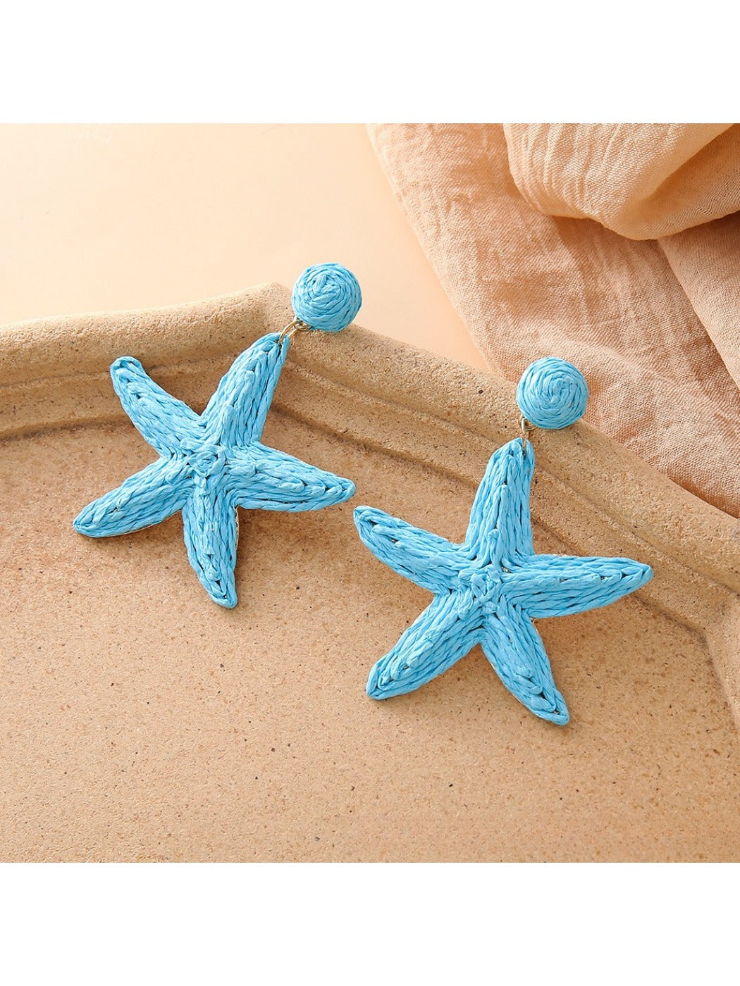 Close-up of textured starfish design on drop earring