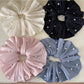 Chic elegant large satin scrunchie in soft beige on white background