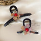 Side view of Beau flower claw clip highlighting curved prongs