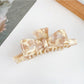 Beau bow shaped claw clip in glossy finish with metal spring detail