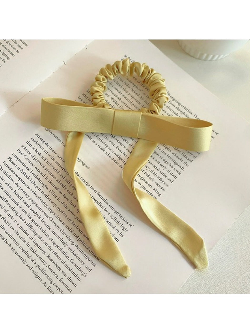Gifty satin yellow ribbon bow scrunchie worn on wrist as accessory