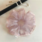 Close-up of a minimalist modern pink ruffled scrunchie on a white background
