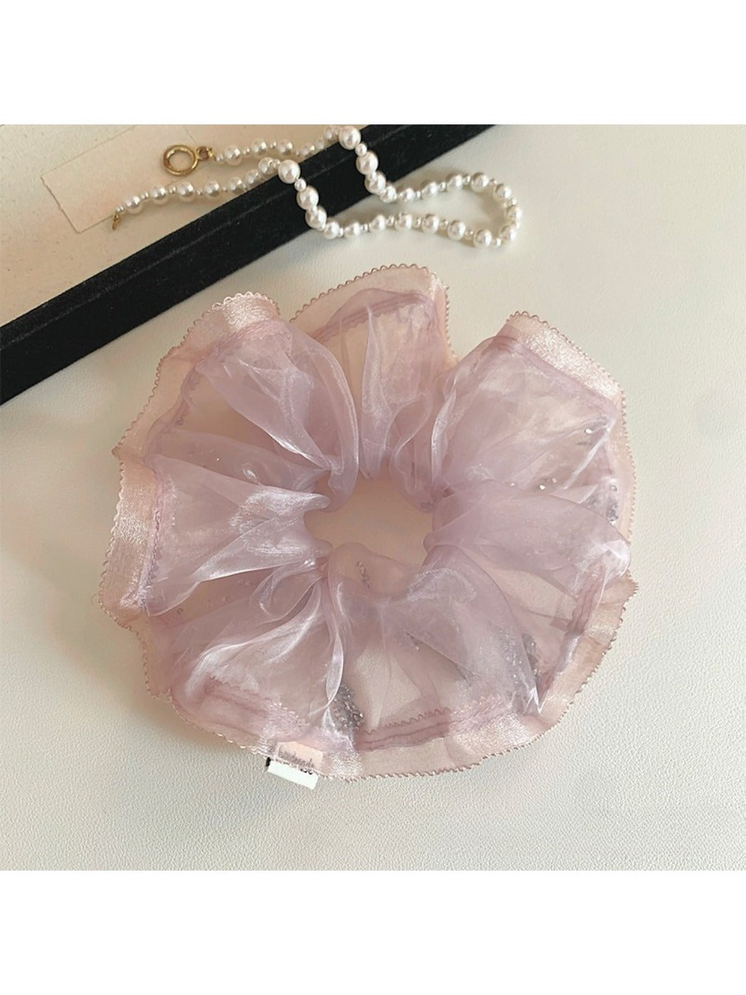 Close-up of a minimalist modern pink ruffled scrunchie on a white background