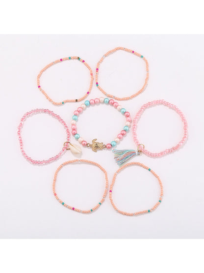 Lovra bracelet worn on wrist showing layered tassel and bead details in natural light