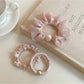 Sweet pink mini scrunchie made of soft fabric on a white background
