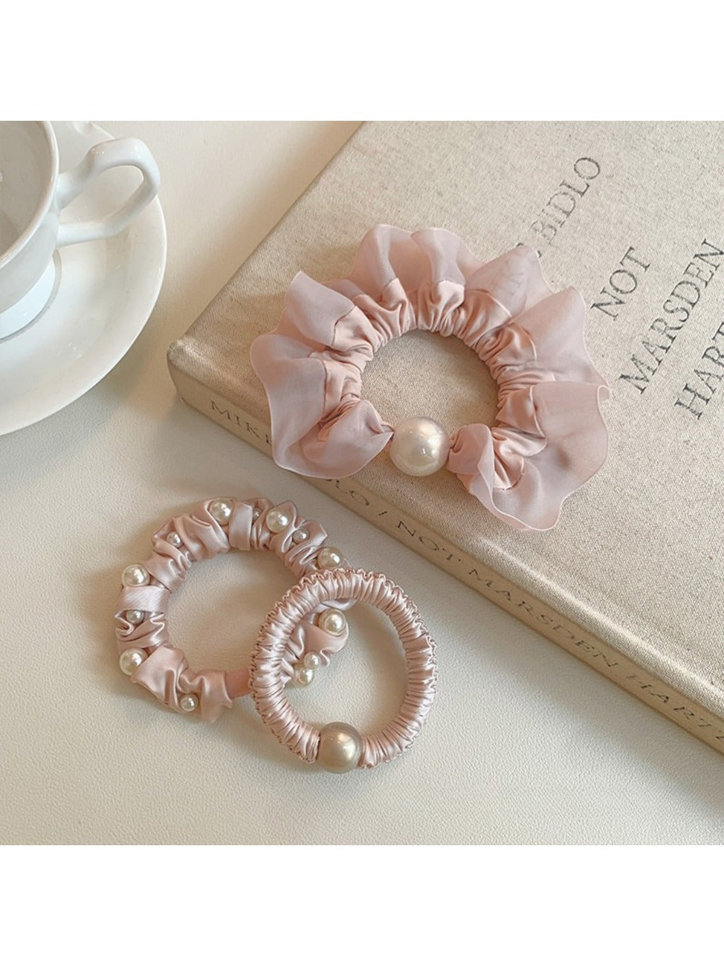 Sweet pink mini scrunchie made of soft fabric on a white background