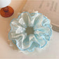 Close-up of a blue lace scrunchie with delicate floral patterns