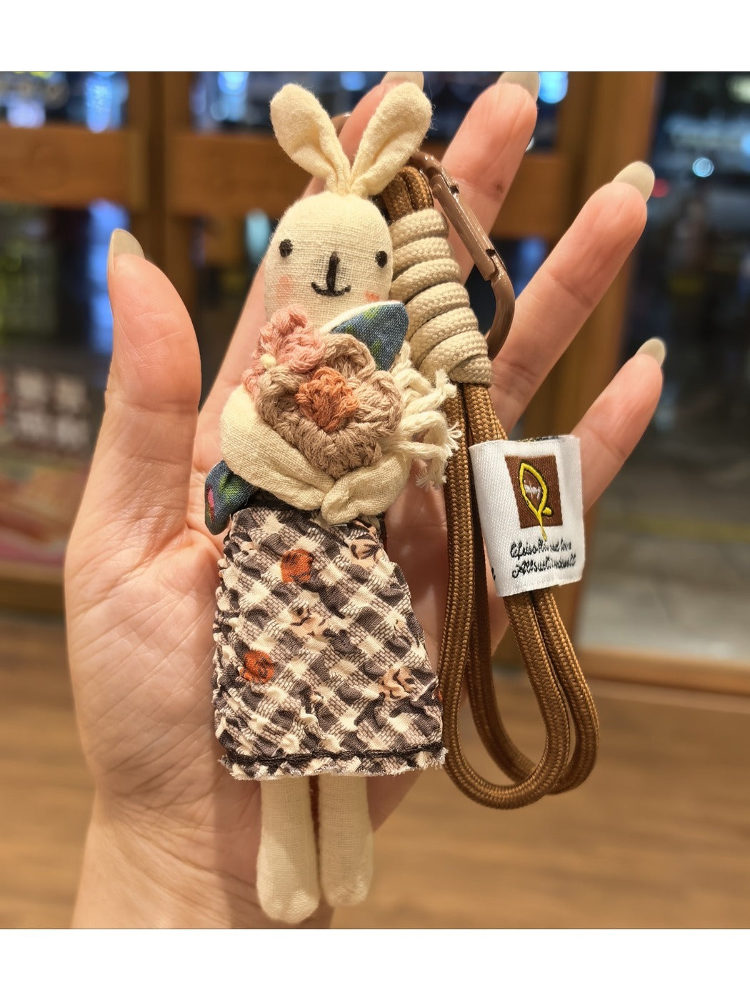Rabbit keychain hanging from a set of keys on a wooden surface