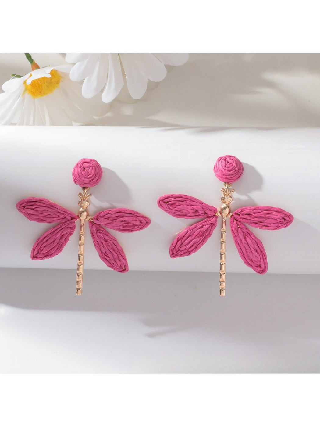 Detailed shot of raffia weaving on dragonfly shaped earring