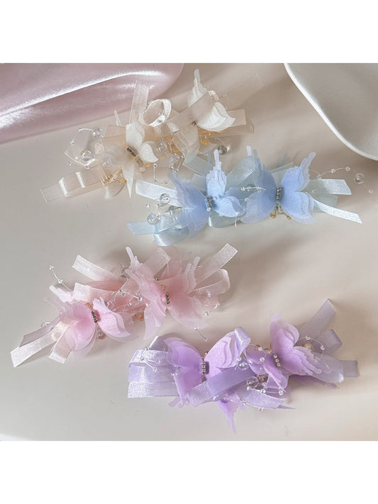 Elegant banana hair clip decorated with gold butterfly accents on a white background