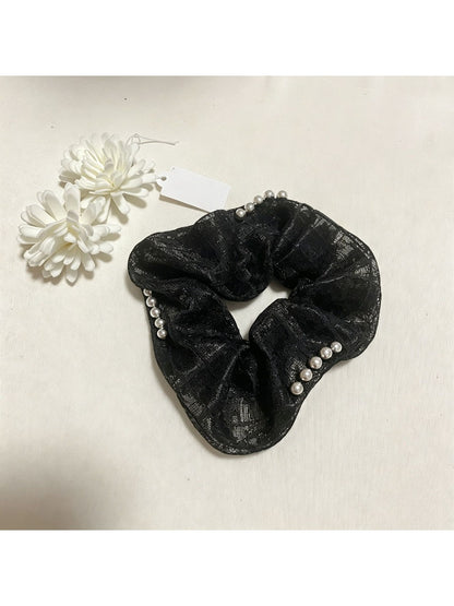 Gifty lace scrunchie styled on a wrist with delicate lace texture visible