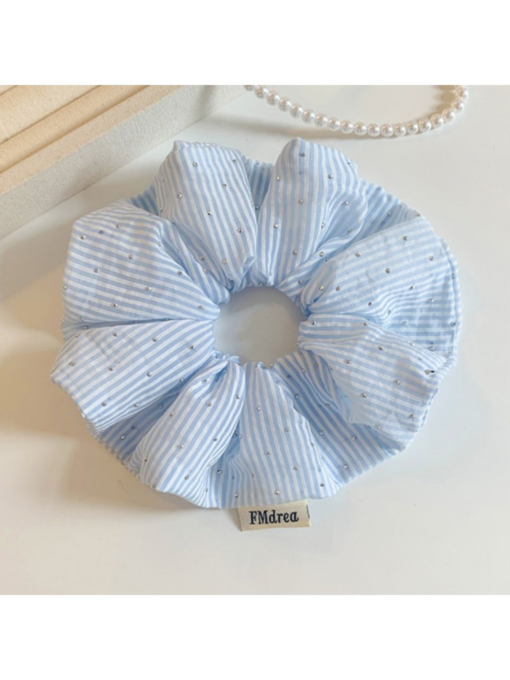Gifty striped scrunchie wrapped around a ponytail on a model with brown hair