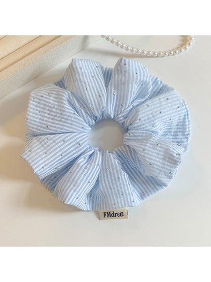 Gifty striped scrunchie wrapped around a ponytail on a model with brown hair