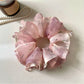 Pink vintage scrunchie styled on a model's wrist as an accessory