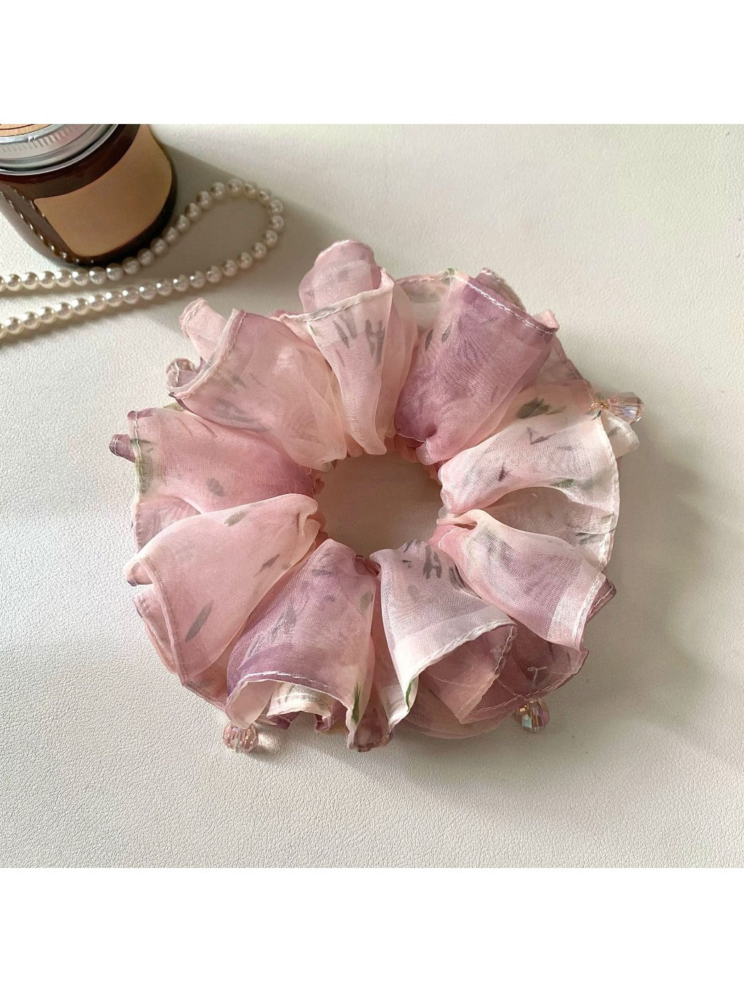 Pink vintage scrunchie styled on a model's wrist as an accessory