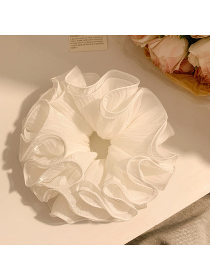 Close-up of elegant white ruffled scrunchie made of soft fabric