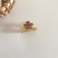 Beau acetate flower hair clip in soft pastel colors placed on a wooden surface