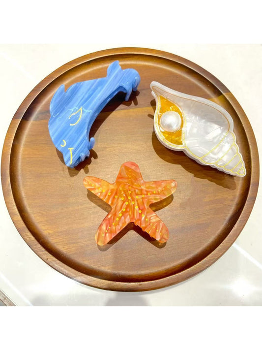 Beau starfish and conch shaped claw clip in beige and brown tones on white background