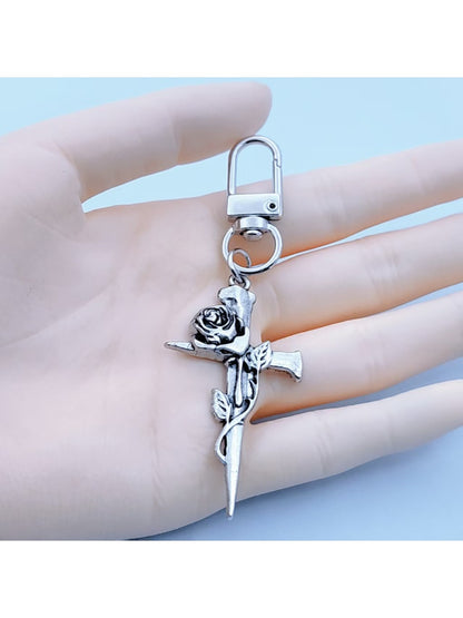 Rose gold cross-shaped keychain with intricate design on white background