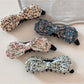 Close-up of Beau bow hair clip showing textured oil painting pattern in blue tones