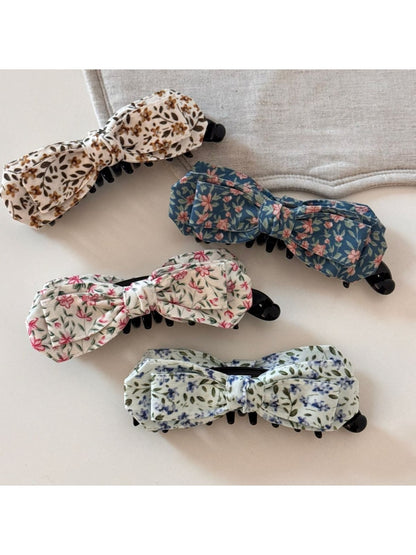 Close-up of Beau bow hair clip showing textured oil painting pattern in blue tones