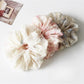 Close-up of Gifty printed ruched scrunchie with floral pattern on fabric