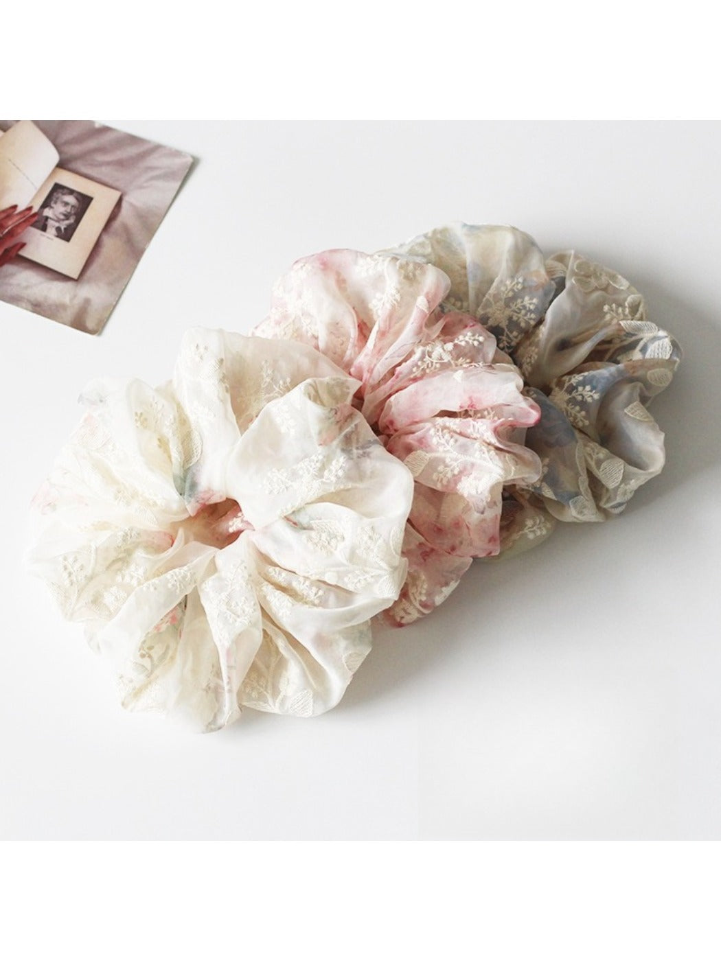 Close-up of Gifty printed ruched scrunchie with floral pattern on fabric